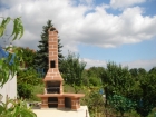 Zahradní krb Beskyd rohový bez levého stolku s fasádou 214,cihla velká. Krb má prodloužený komín s udírničkou.
