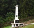 Zahradní rohová  udírna v bílé povrchové úprav, doplněná o udírničku v komíně a 5 kusů komínového nástavce. Celková výška pod čepici je 350 cm.