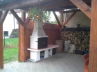 Zahradní krboudírna Rožmberk s bílou fasádou a prodlouženým komínem.